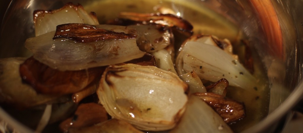 Onions and garlic from roasting chicken in pan with juices